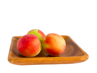 Peaches on wooden plate.
