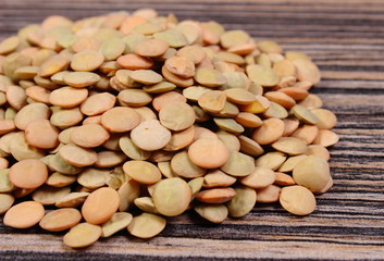 Heap of green lentil on wooden background