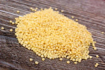 Heap of millet groats on wooden background