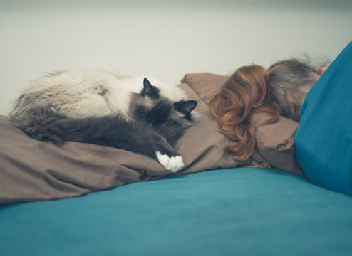 Woman Sleeping In Bed With Cat