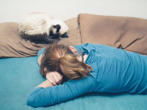 Woman sleeping in bed with cat