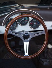 wooden steering wheel and leather dashboard of a classic car
