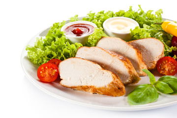 Roast chicken fillet and vegetables on white background