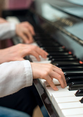 Obraz premium Woman teaching little girl to play the piano.