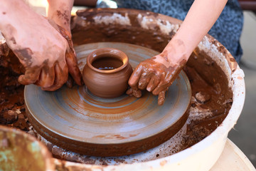 Hands working on pottery wheel