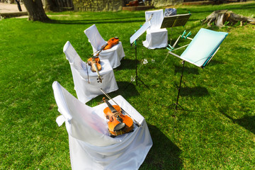 Outdoors wedding ceremony - string quartet's chairs with instrum
