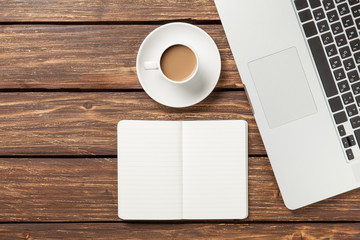 Cup of coffee and notebook with laptop computer