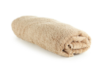 Fototapeta na wymiar Rolled up beige towel isolated on white