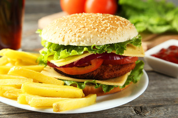 Fresh burgers on plate on grey wooden background