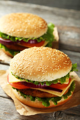 Fresh burgers on grey wooden background