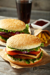 Fresh burgers on grey wooden background