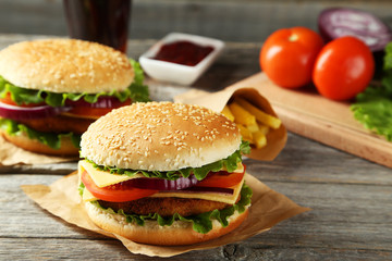 Fresh burgers on grey wooden background
