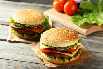 Fresh burgers on grey wooden background