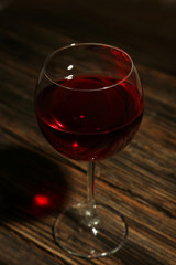 Red wine glass on brown wooden background