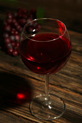 Red wine glass on brown wooden background
