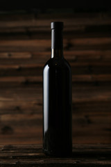 Bottle of red wine on brown wooden background