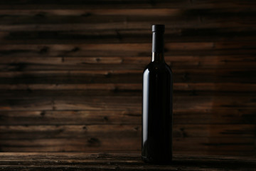Bottle of red wine on brown wooden background