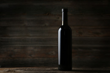 Fototapeta na wymiar Bottle of red wine on grey wooden background