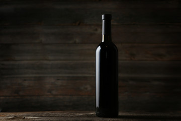 Bottle of red wine on grey wooden background