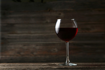 Red wine glass on grey wooden background