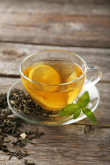 Cup with green tea on grey wooden background