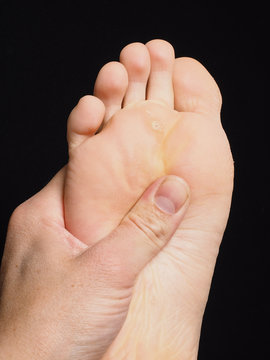 Pressure point massage under foot with thumb isolated towards bl