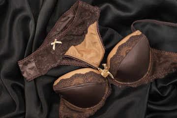 Sexy brown lingerie lying on black satin