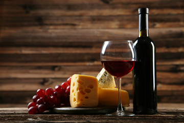 Glass of red wine, cheeses and grapes 