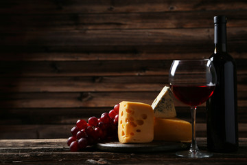 Glass of red wine, cheeses and grapes 