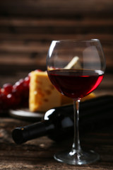 Glass of red wine, cheeses and grapes 