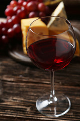 Glass of red wine, cheeses and grapes 