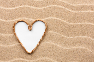 Heart made of rope with a white background on the sand