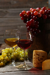 Glass of red wine, cheeses and grapes 