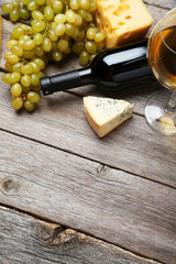 Obraz premium Glass of red and white wine, cheeses and grapes 