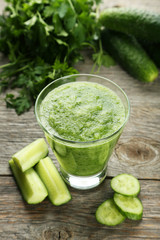 Glass of cucumber juice on grey wooden background