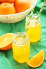 Orange juice in bottle and orange in basket 