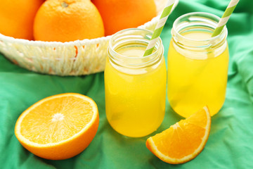 Orange juice in bottle and orange in basket 