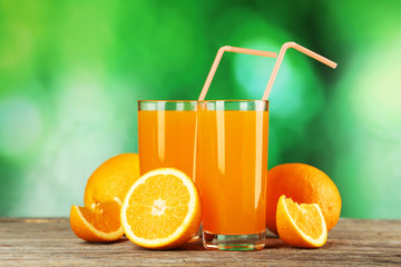 Glass of fresh orange juice on wooden background