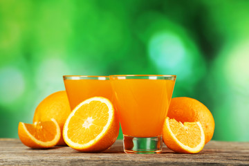 Glass of fresh orange juice on wooden background