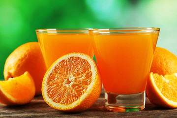 Glass of fresh orange juice on wooden background