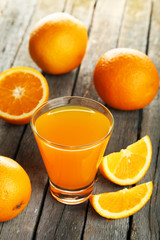 Glass of fresh orange juice on wooden background