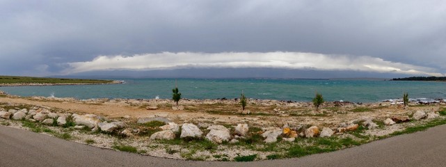 Stone beach with dramatic clouds of approaching storm 