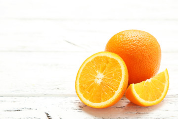 Fototapeta na wymiar Ripe oranges on white wooden background