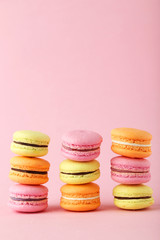 French colorful macarons on pink background
