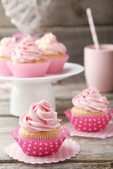 Tasty cupcake on grey wooden background
