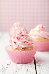 Tasty cupcake on white wooden background