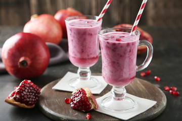 Pomegranate smoothie in glass on black background