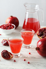 Pomegranate juice in glass on wooden background
