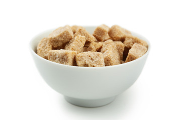 Brown sugar in spoon and bowl on wooden background
