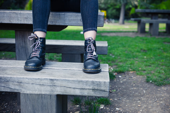 Woman wearing boots sitting on bench